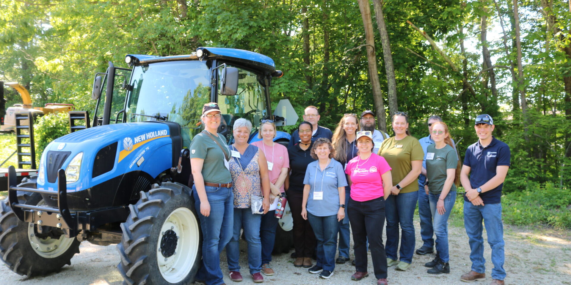 group of NEASHC members next to a blue tractor