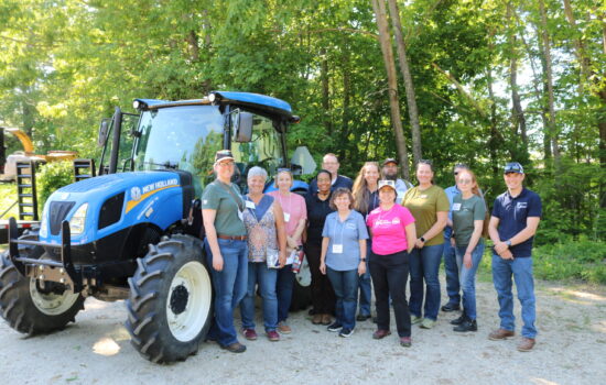 group of NEASHC members next to a blue tractor