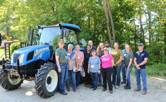 group of NEASHC members next to a blue tractor