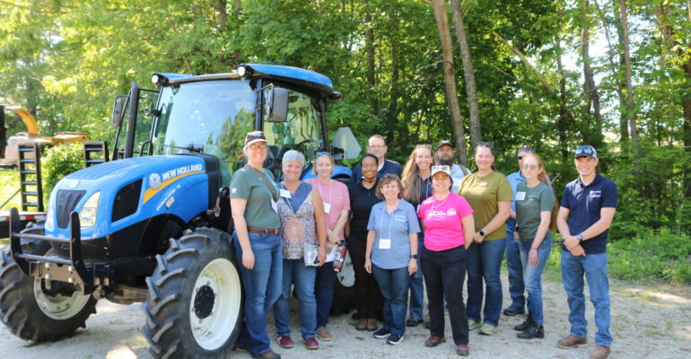 group of NEASHC members next to a blue tractor