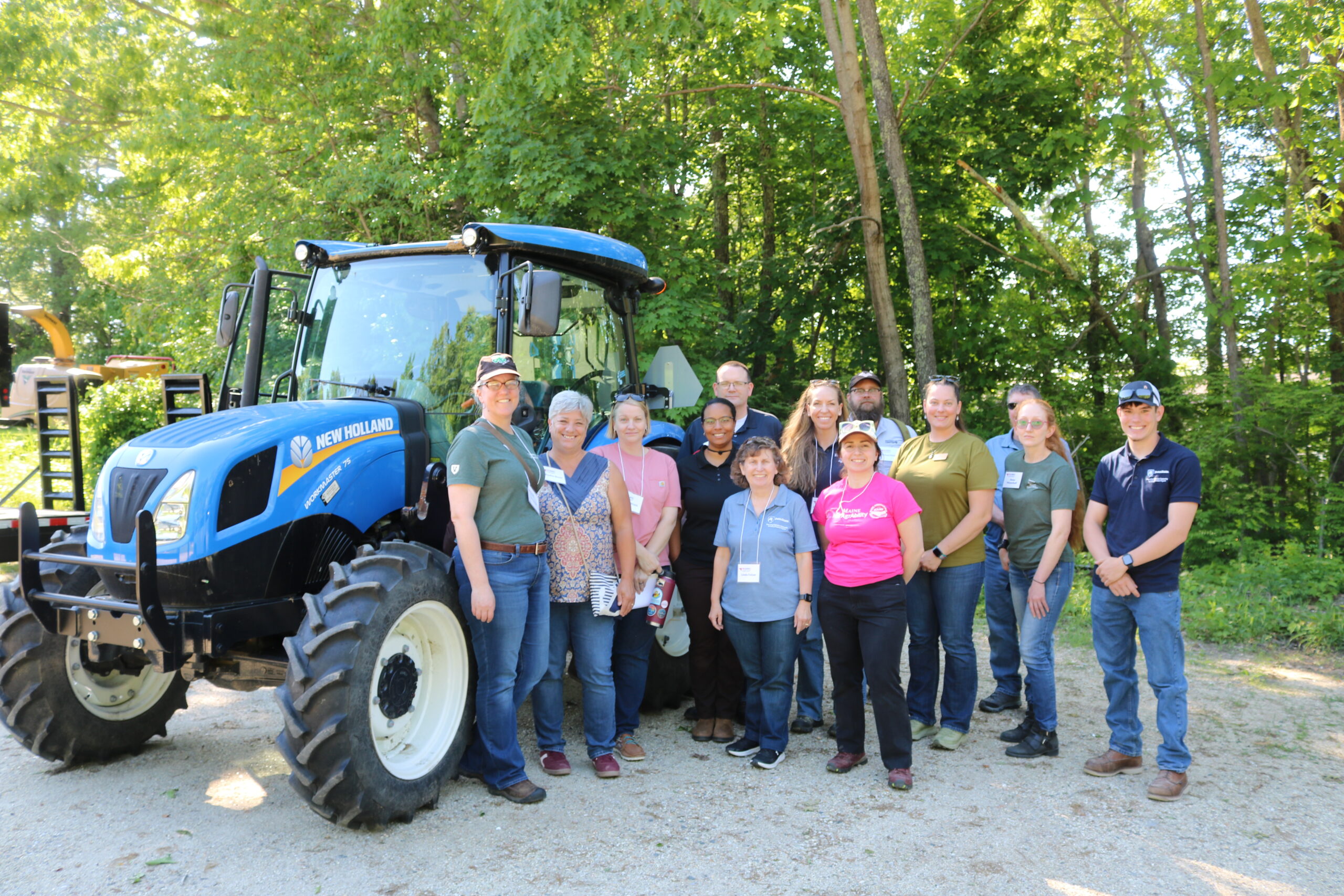 group of NEASHC members next to a blue tractor